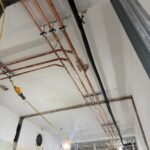 Copper water pipework supported at high level along the ceiling at Kestral House School