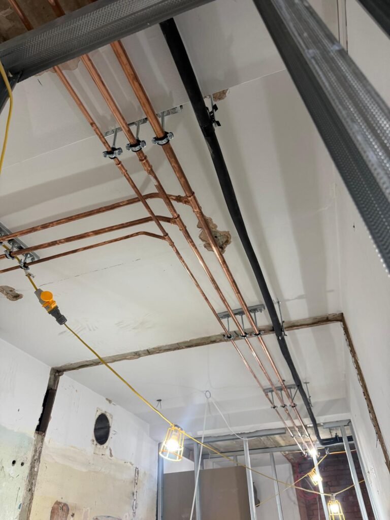 Copper water pipework supported at high level along the ceiling at Kestral House School