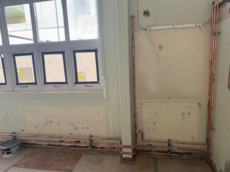 New copper water pipework run at low level along a wall at Kestral House School