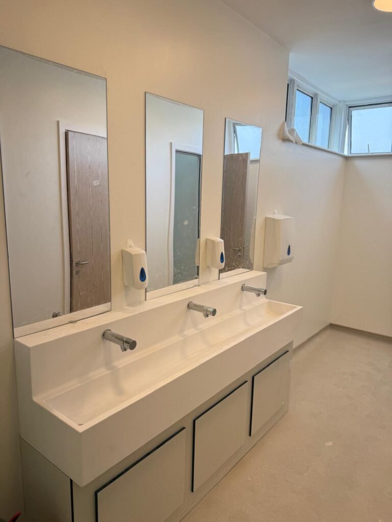 Finished school washroom at Kestral House School with a wash trough, taps and mirrors